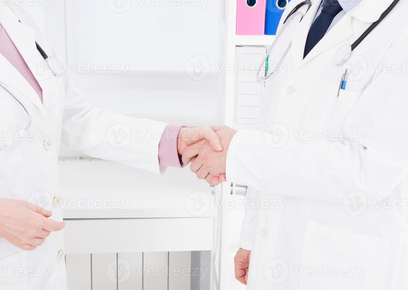 two doctors shake hands at the clinic. Medical insurance. Healthcare concept. Copy space photo