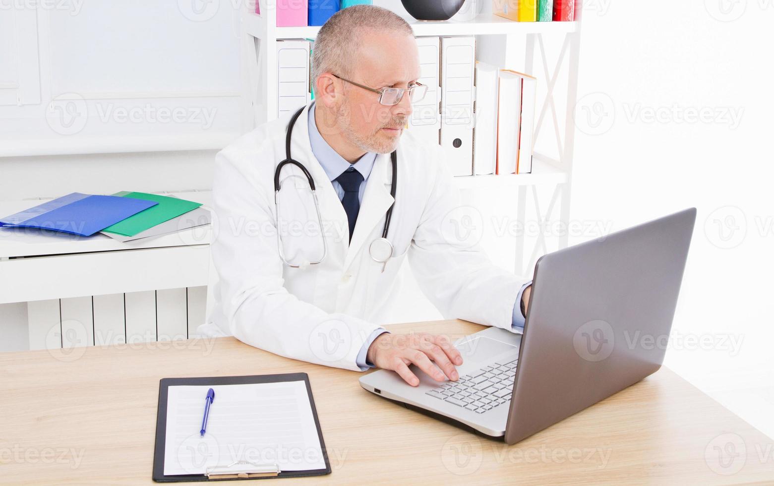 doctor works at the computer in clinic office photo