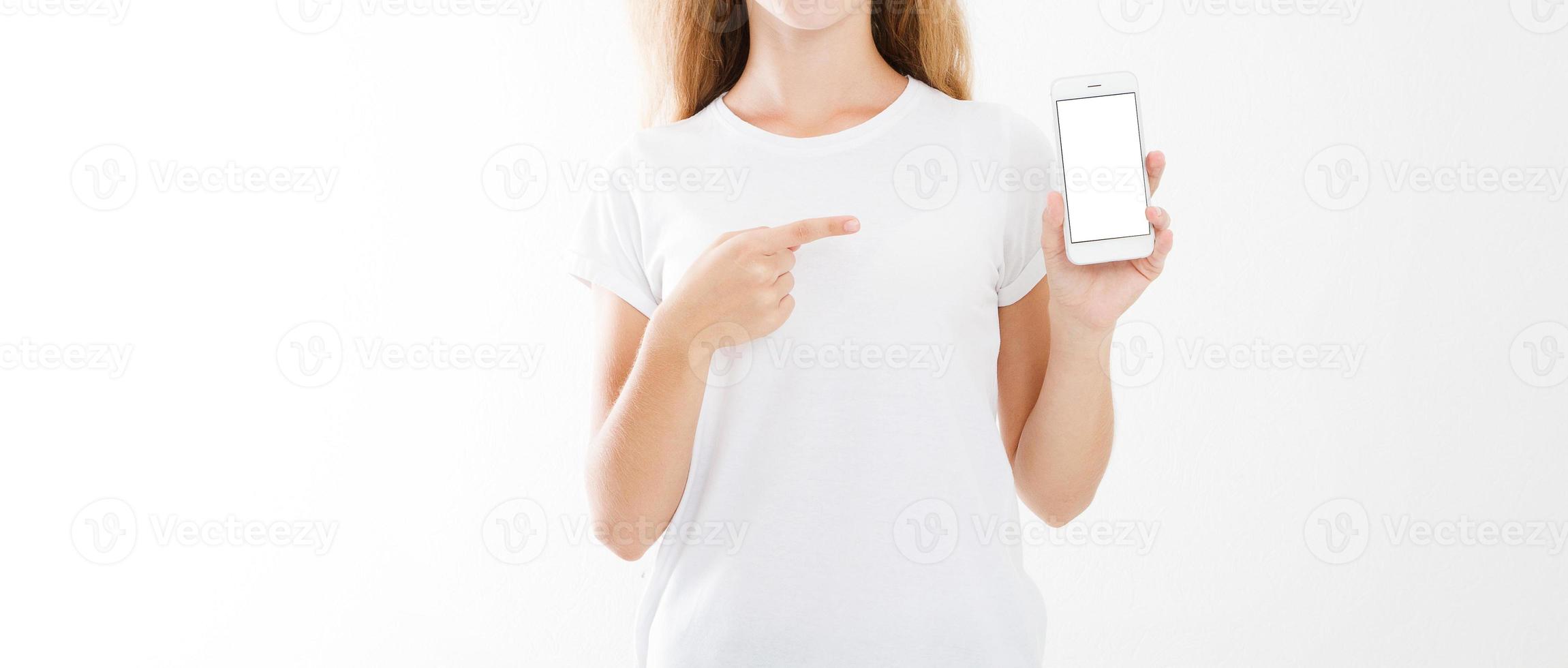 niña, mujer en camiseta dedo acusador en el teléfono móvil de pantalla en blanco aislado sobre fondo blanco. mano que sostiene el teléfono inteligente. copia espacio foto