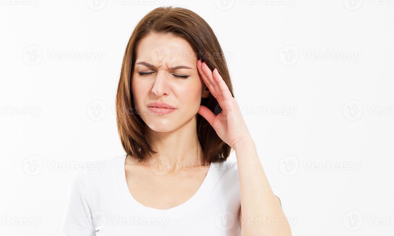 Mujer que sufre de estrés o dolor de cabeza haciendo muecas de dolor mientras sostiene la parte posterior del cuello con la otra mano en la sien sobre fondo blanco. foto