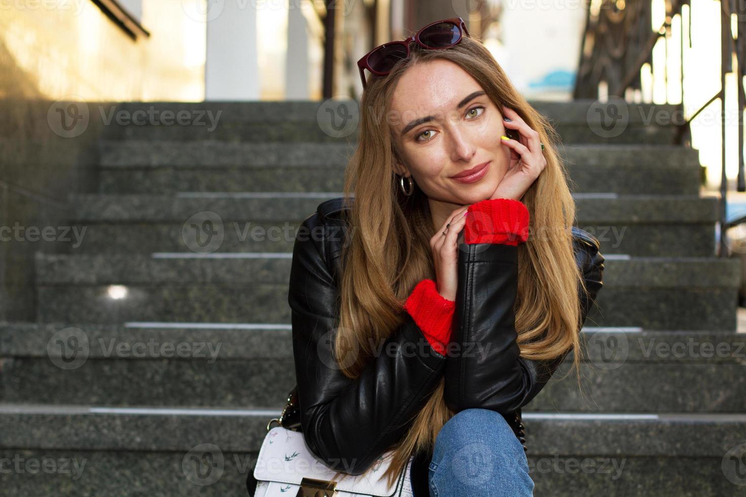 Close up Beautiful white young woman wearing sunglasses, stylish sweater and leather jacket posing on the street, beautiful sexy stylish smile woman on urban background, white women in Big City photo