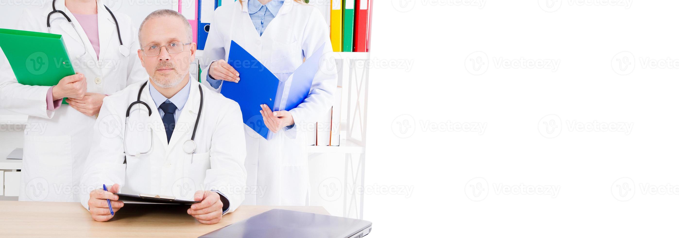 médico masculino con material médico sentado en la oficina de la clínica, seguro médico, espacio de copia, valla publicitaria o pancarta foto