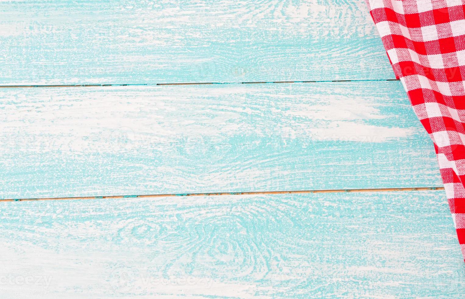 top view blue empty wooden table and red checkered tablecloth photo