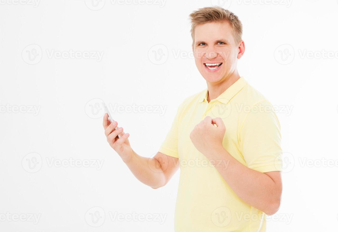 young man showing success symbol and holding phone on white background photo