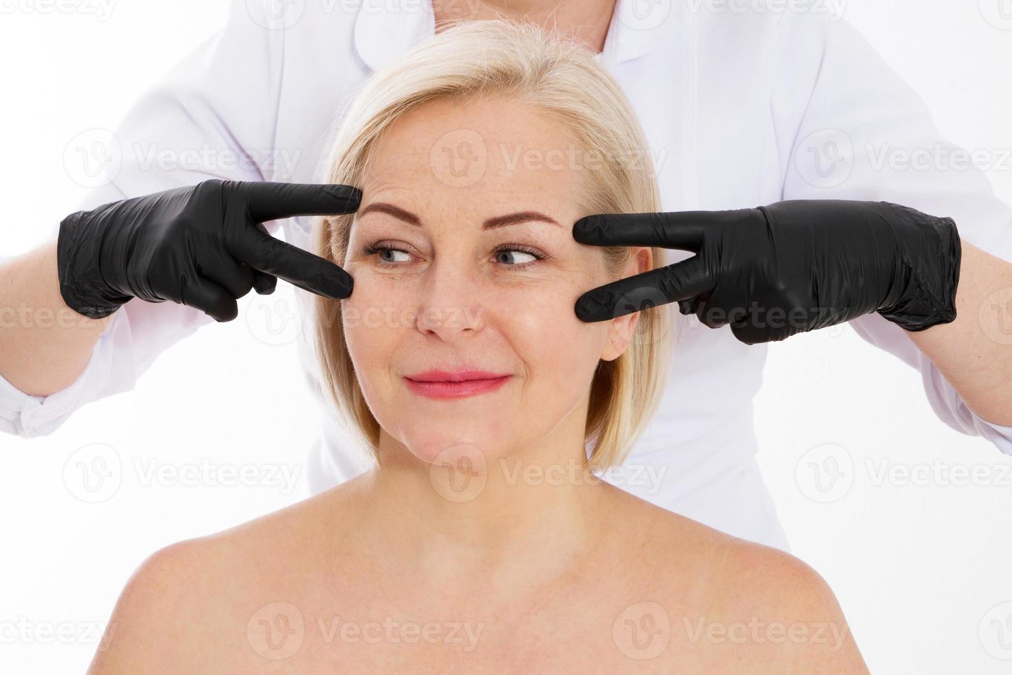 Wrinkles on the face of a beautiful middle-aged woman, women at a beautician appointment, beautician's hands close up photo