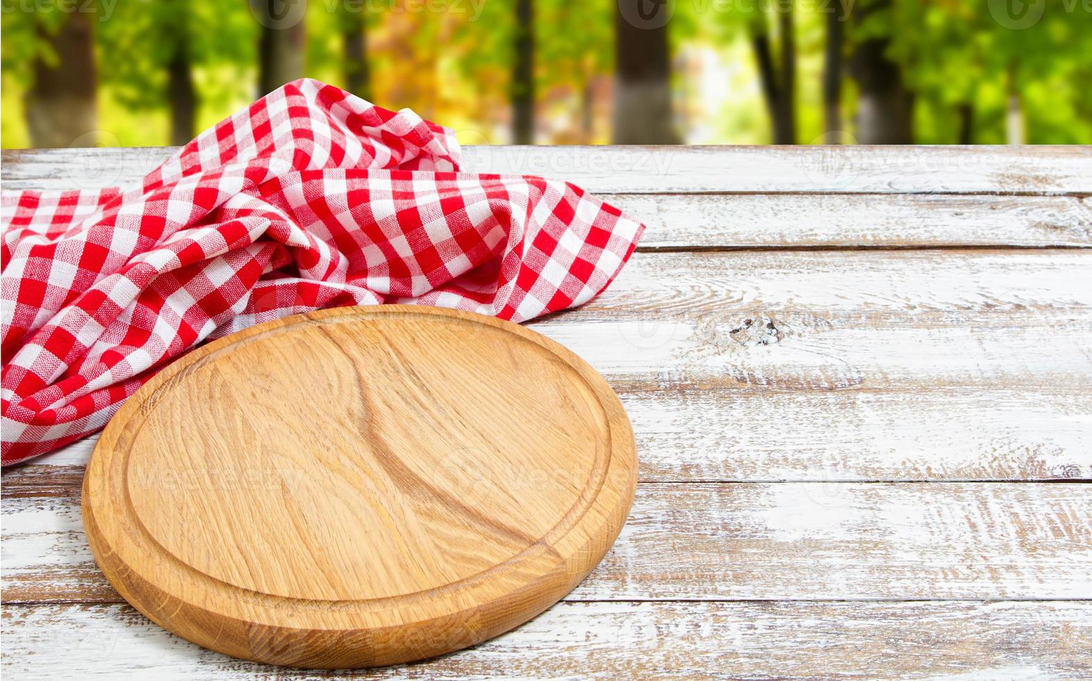 servilleta y tabla para pizza en primer plano de escritorio de madera, mantel. lienzo, paños de cocina en la vista superior de fondo de mesa de madera blanca simulacro. enfoque selectivo foto