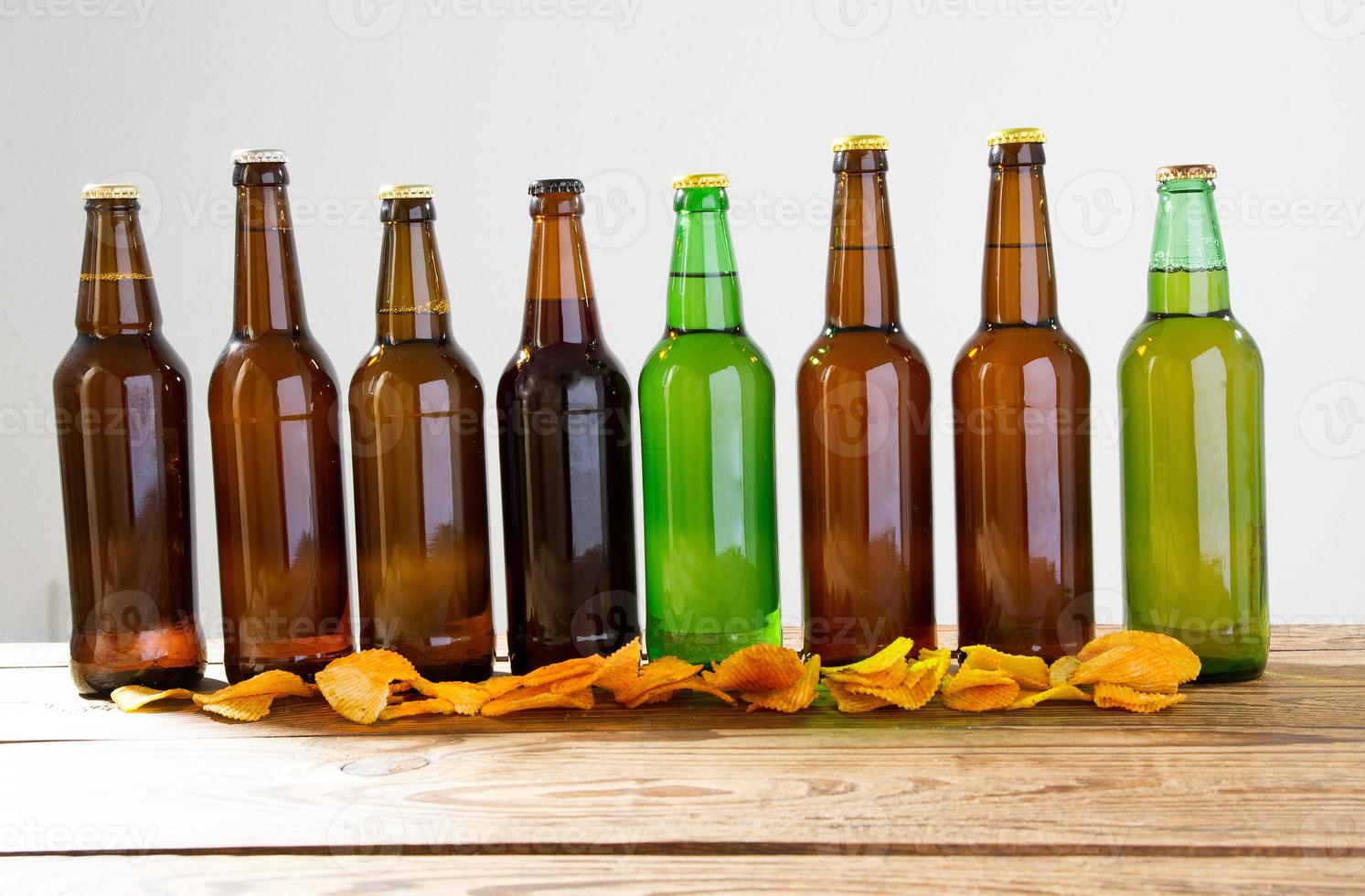 Beer bottles on a wooden table . Potato chips. Top view. Selective focus. Mock up. Copy space.Template. Blank. photo