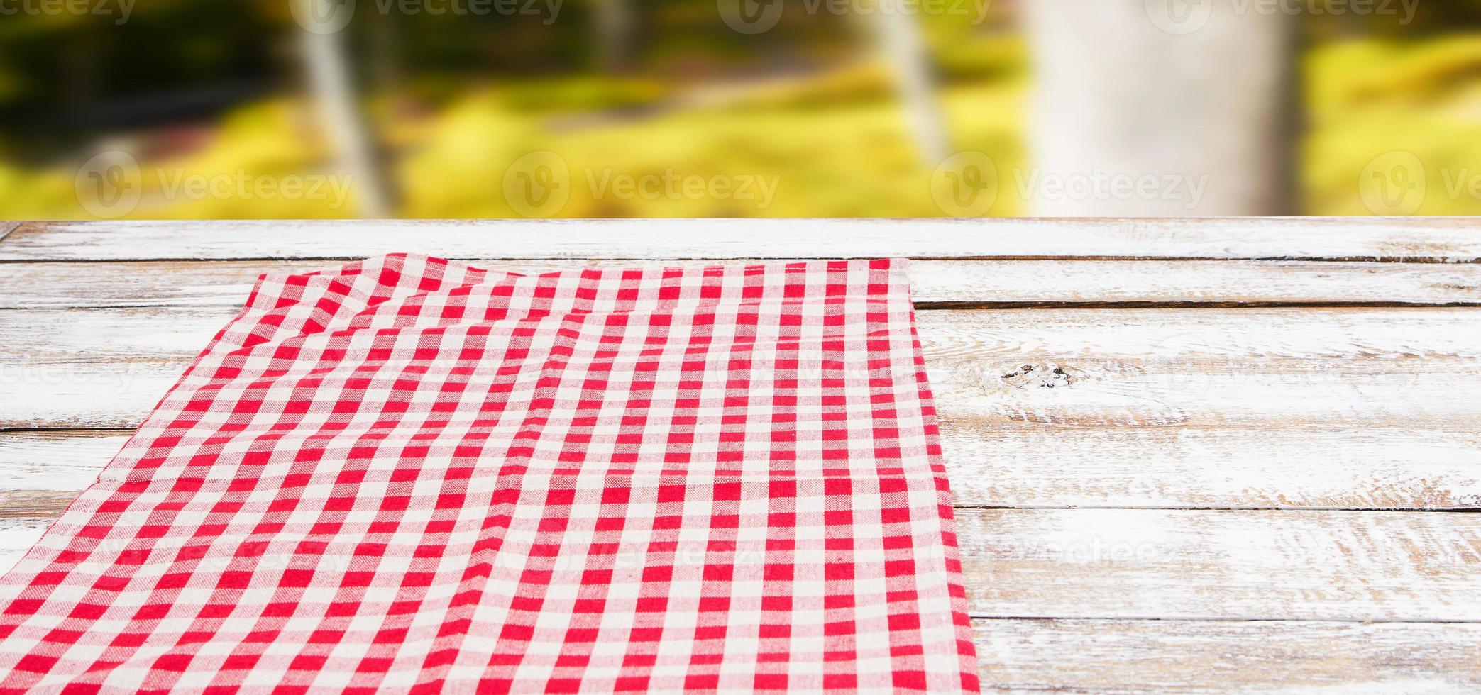 checkered red tablecloth on an empty table - top view photo