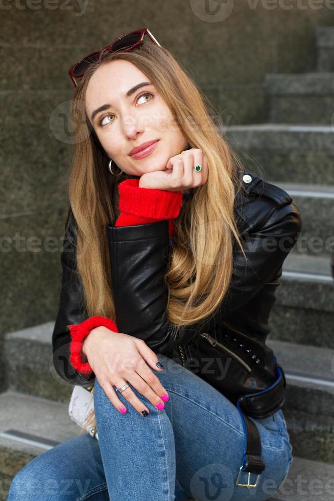 Close up Beautiful white young woman wearing sunglasses, stylish sweater and leather jacket posing on the street, beautiful sexy stylish smile woman on urban background, white women in Big City photo