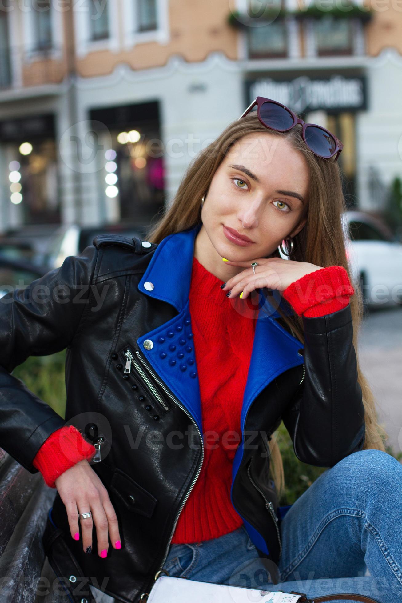 Outdoor waist up fashion portrait of young beautiful sensual woman wearing  stylish leather cap, trendy yellow sunglasses, sexy lace bra, tartan blazer,  posing in street of the city. Copy, empty space Stock