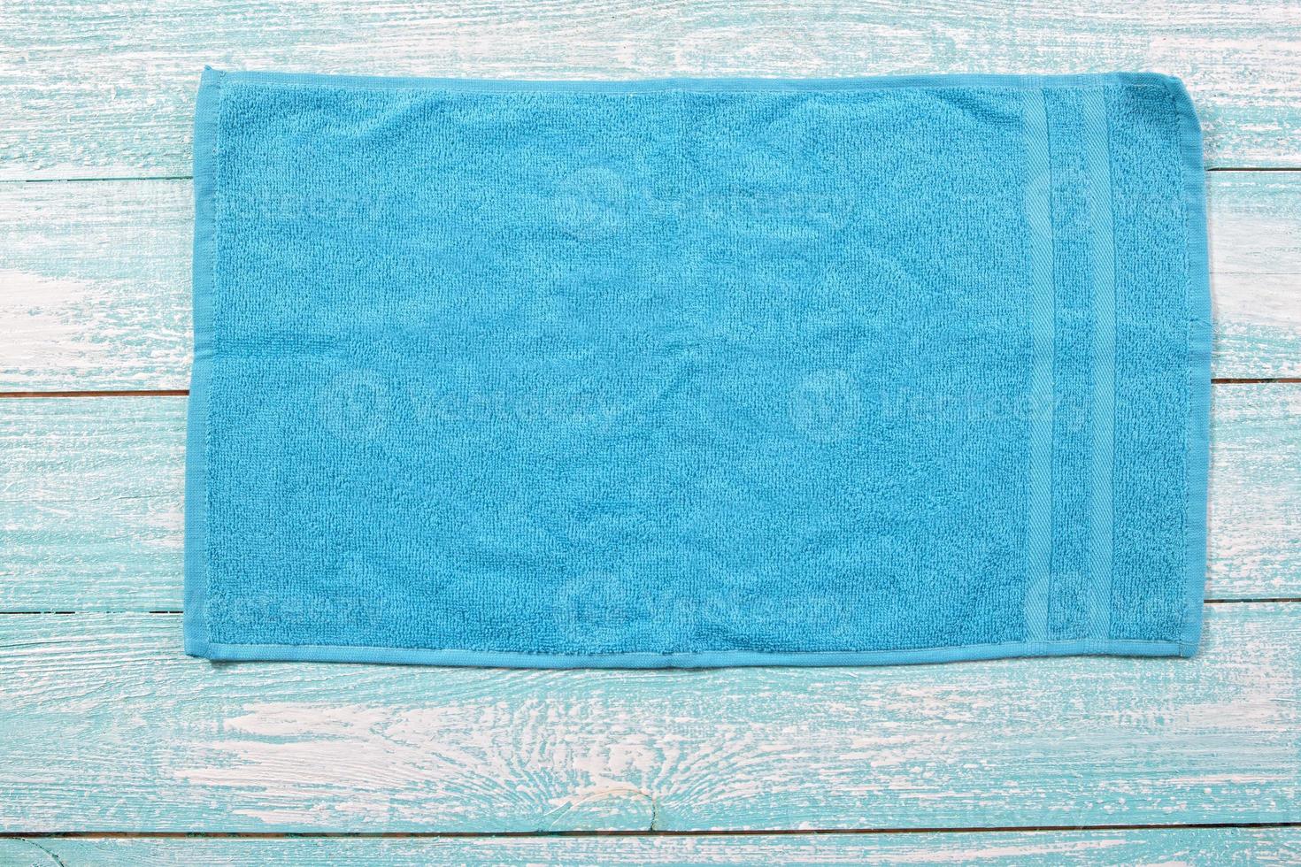 Vista superior de la toalla azul sobre tablero azul de madera de cerca el espacio de copia. primer plano de la servilleta suave azul foto