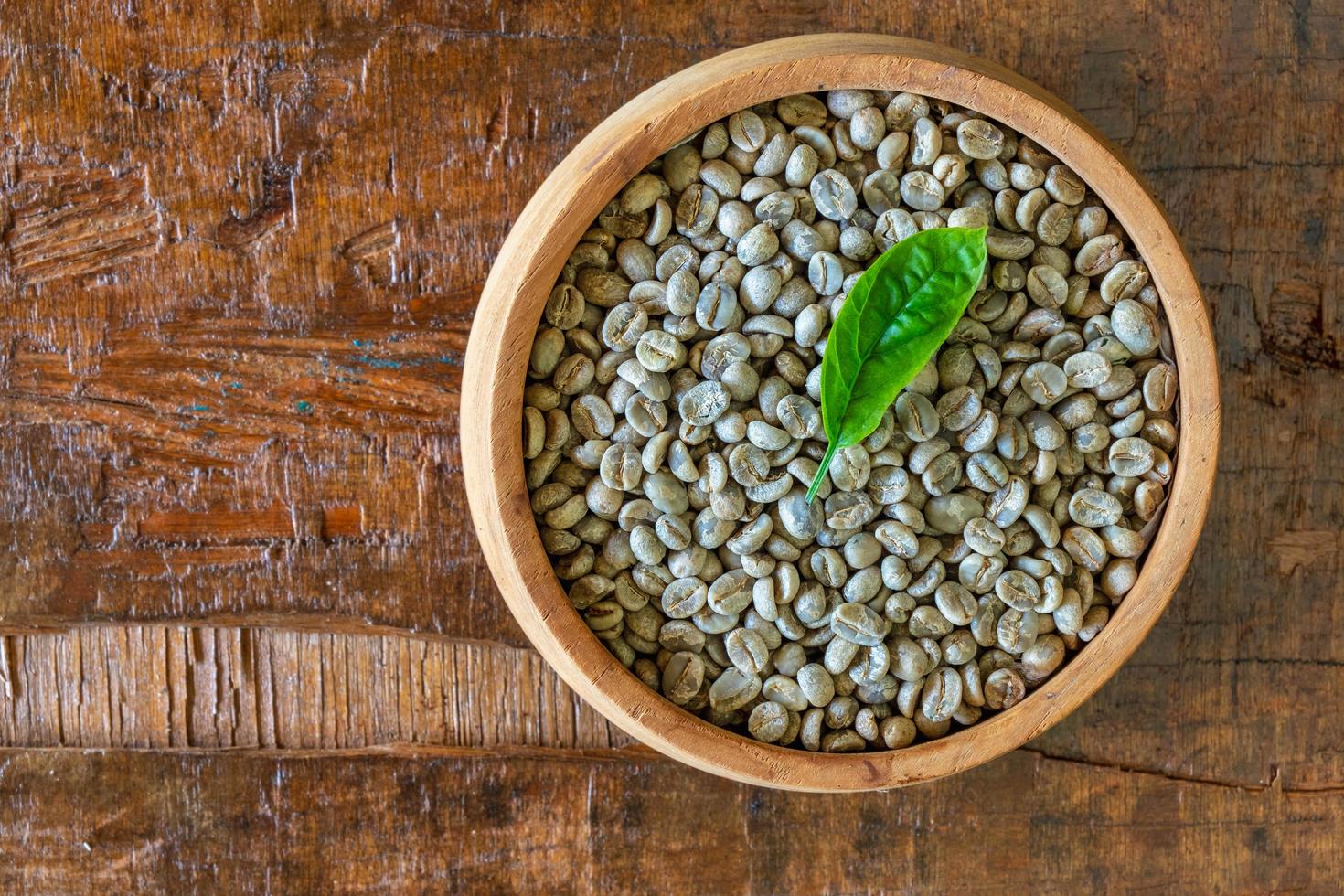 unroasted green coffee beans in a wooden bowl photo
