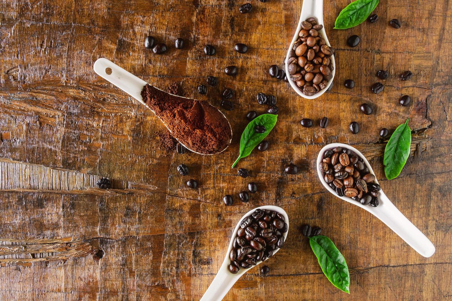 A collage of coffee beans in spoon showing various stages  through to roast photo