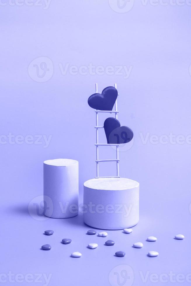 A podium with a wooden staircase and hearts in a trendy color very peri, monochrome. Celebrating Valentine's Day copy space. Vertical format photo