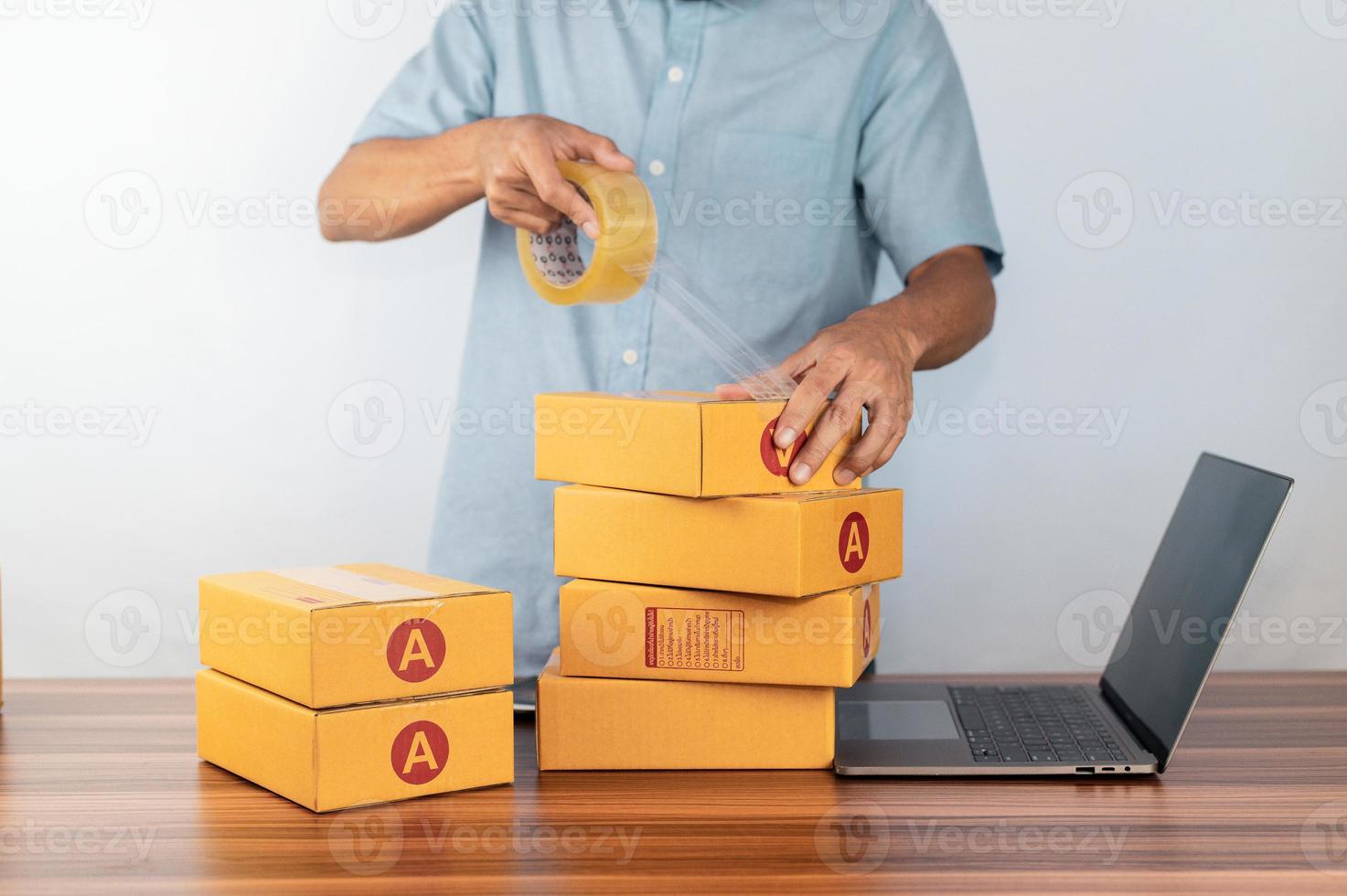 Man using tape for packing box for selling online business, photo