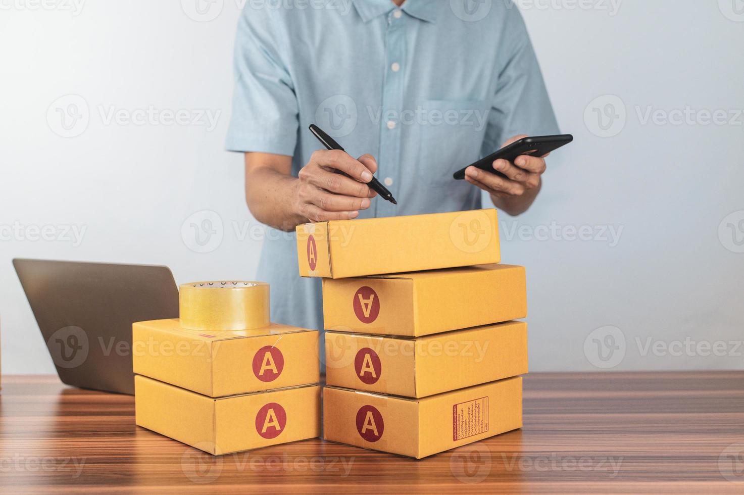 Man is writing an address for shipping to an online store customer. photo