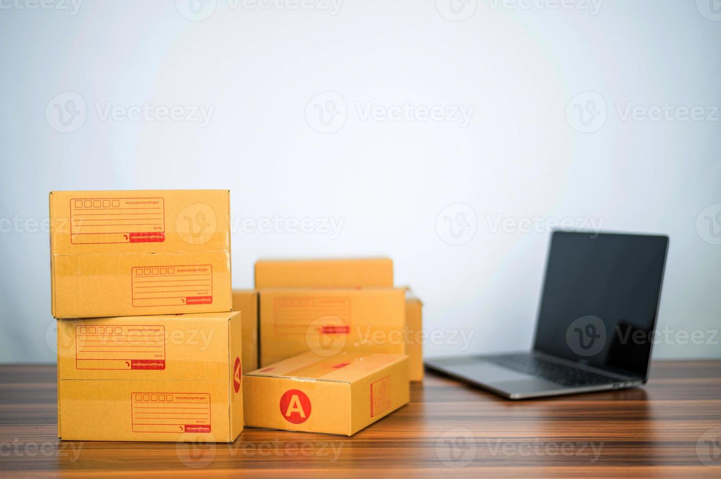 The box for sending to customers is on the table and there is a computer to receive online store orders, selling online businesses that are becoming popular nowadays, convenient shop online services photo