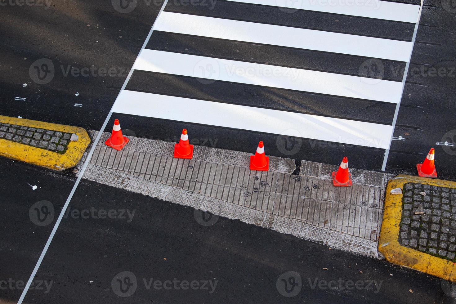 Freshly painted zebra crossing on a city road with cones and masking tape on the asphalt photo