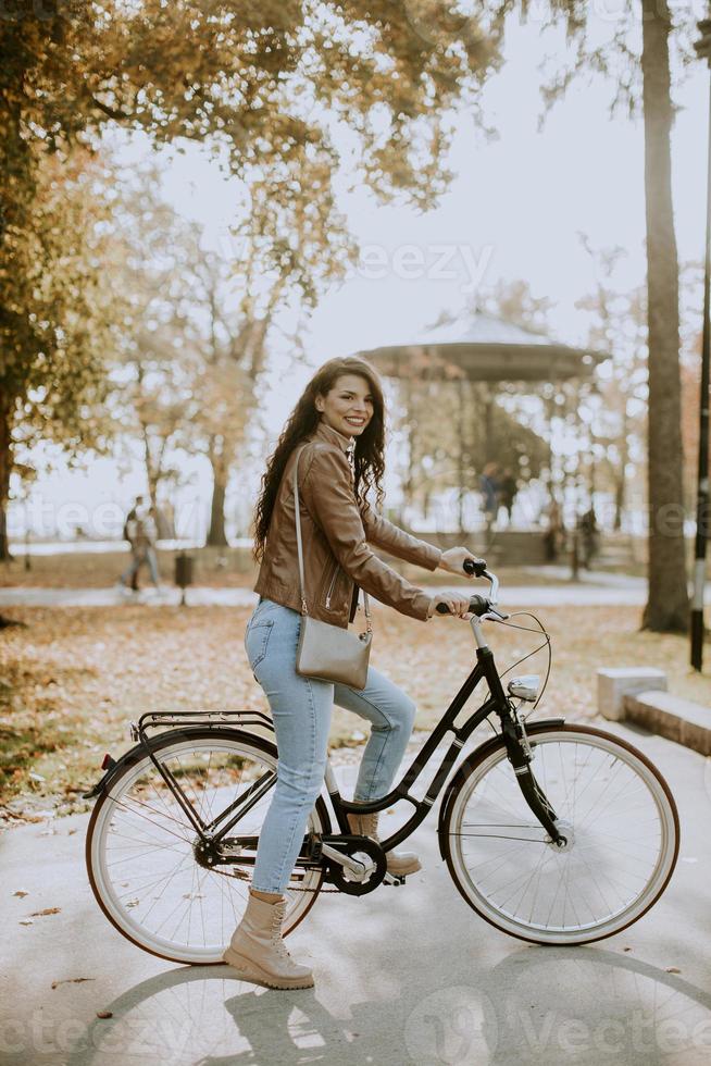 mujer joven montando bicicleta en el día de otoño foto