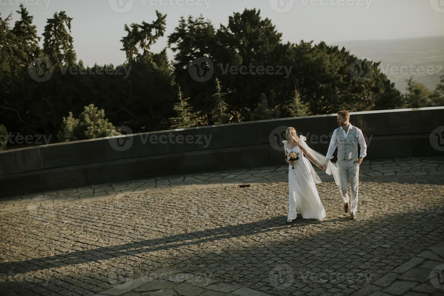 joven pareja de recién casados caminando en el parque foto