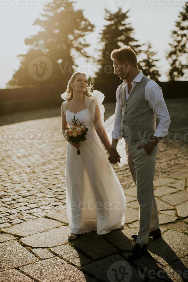 joven pareja de recién casados caminando en el parque foto