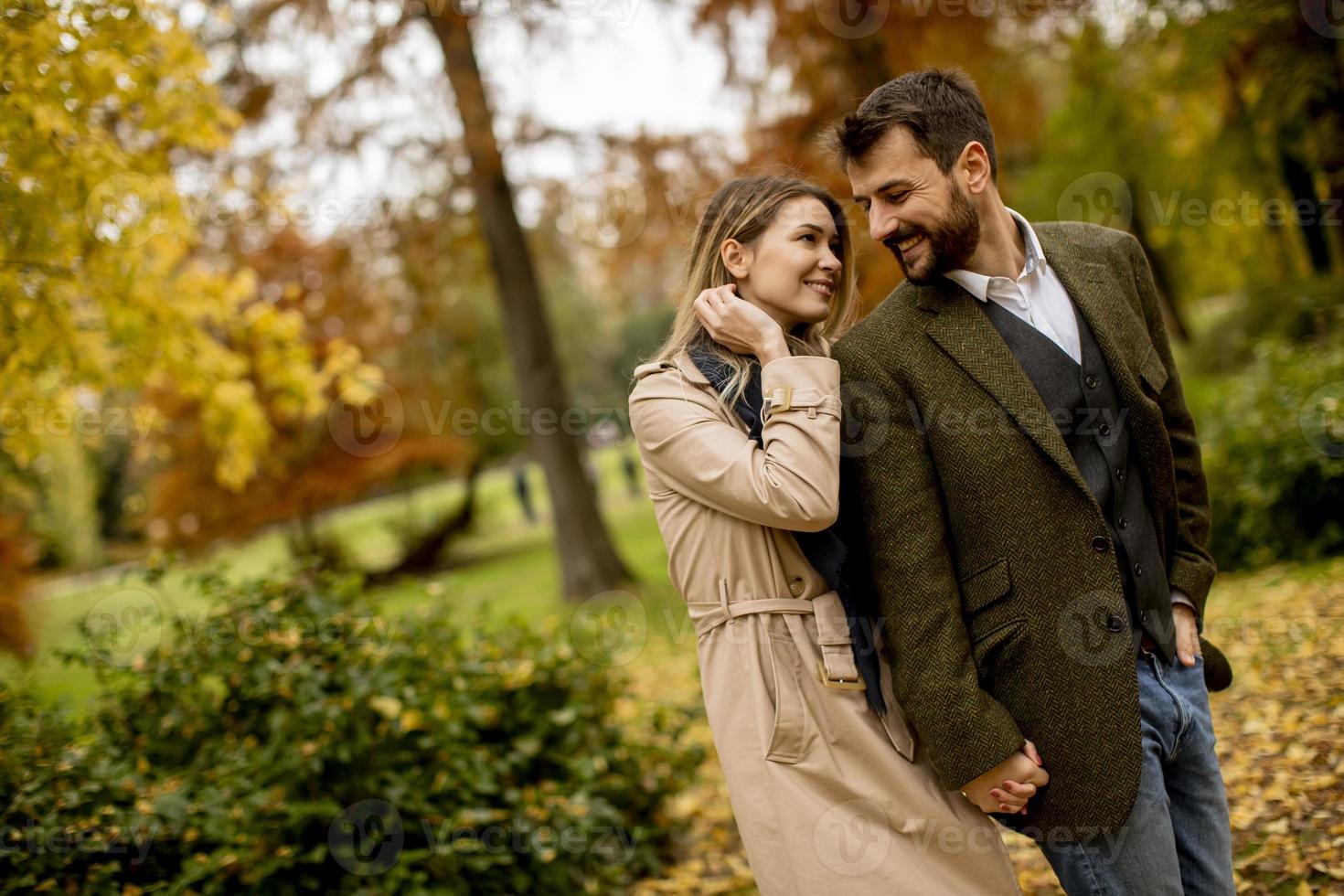 pareja joven caminando en el parque de otoño foto