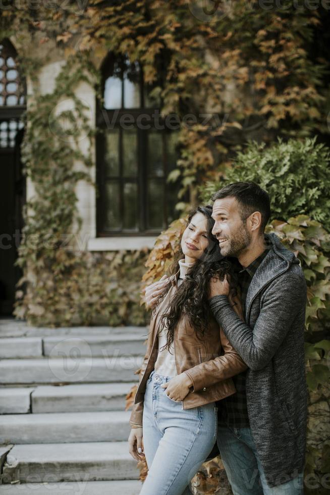 Young couple standing by the stairs in autumn park photo