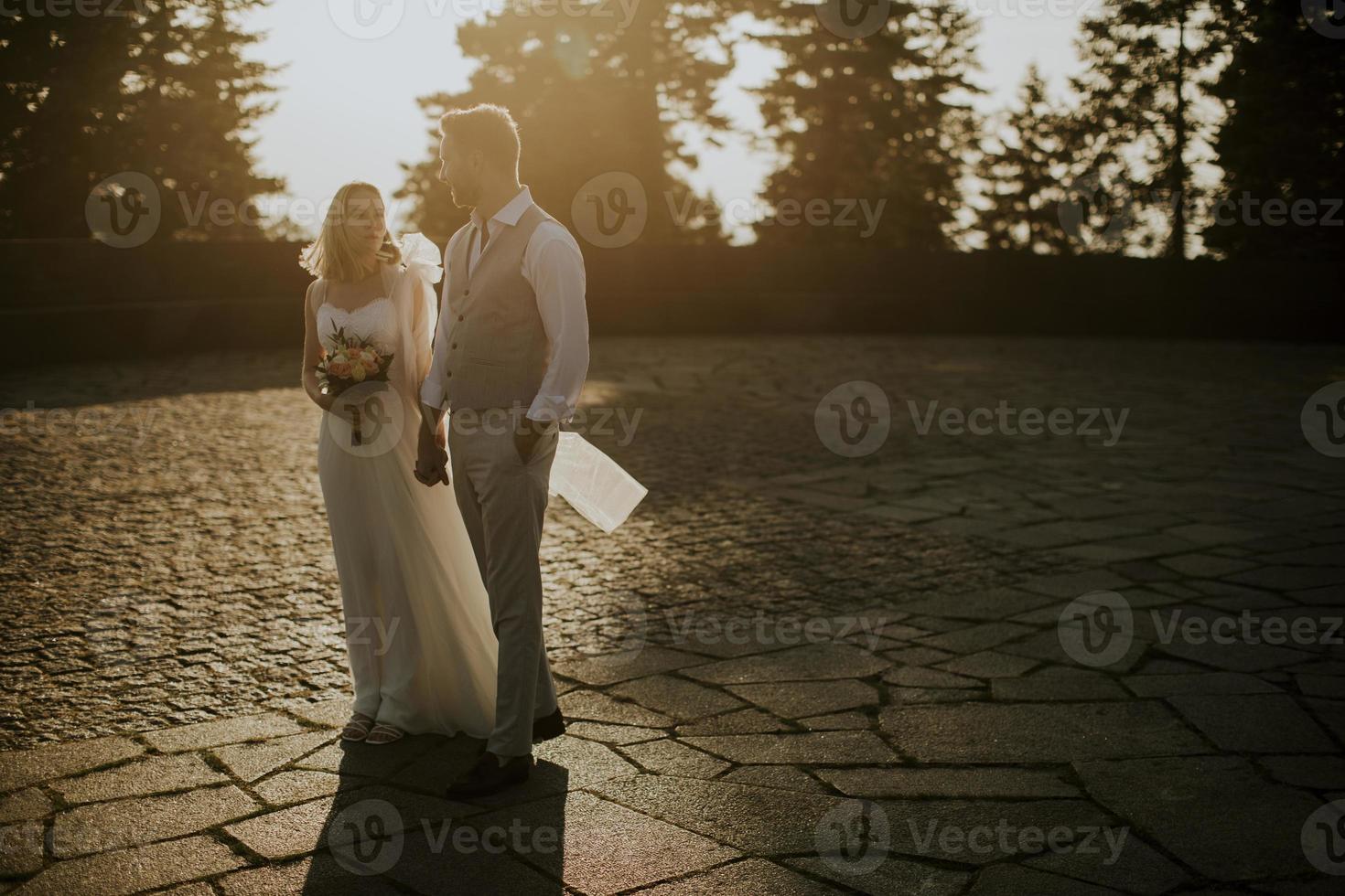 Young newlywed couple walking in the park photo