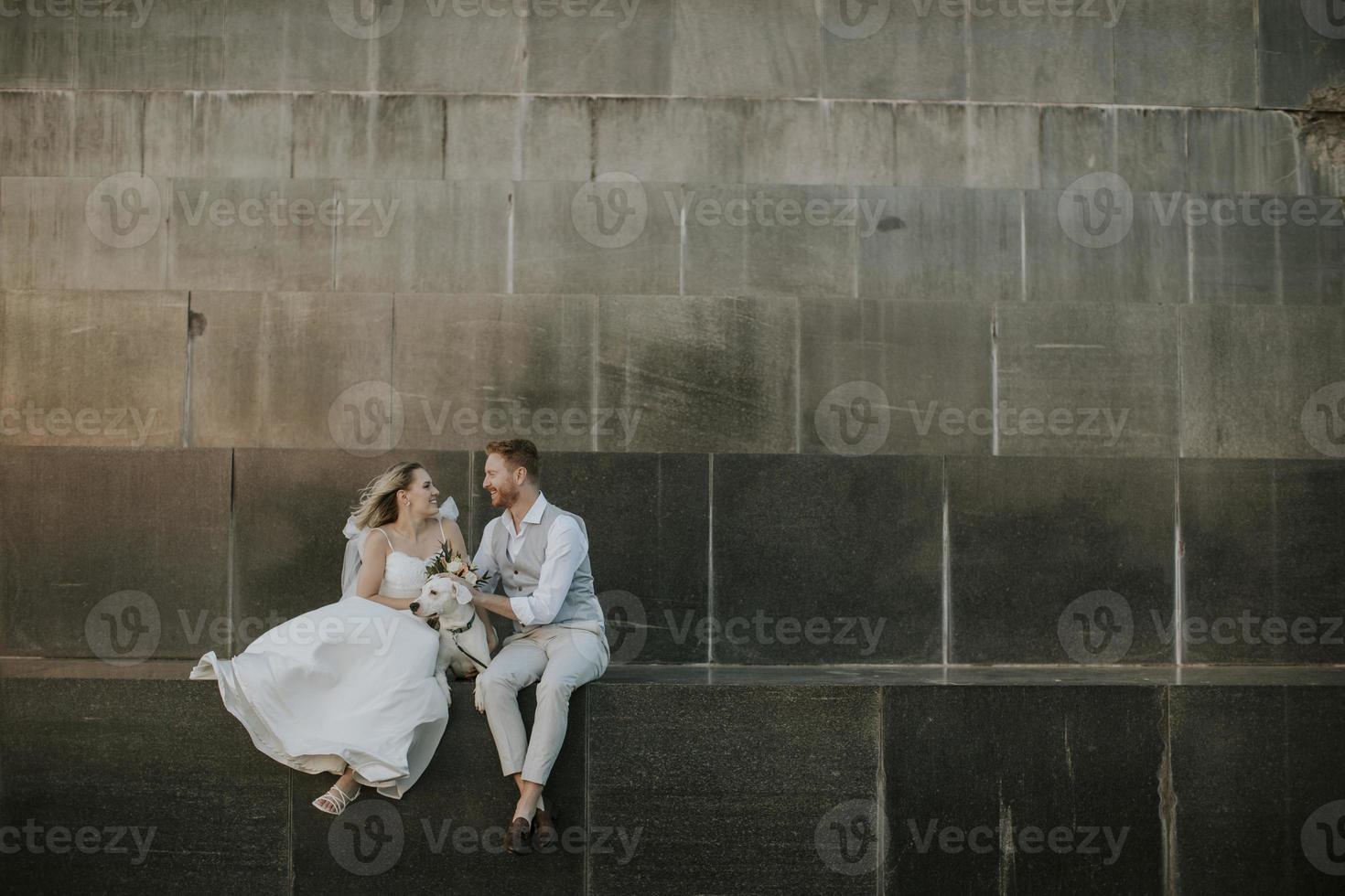 Joven pareja de recién casados con su perro jack russel terrier foto