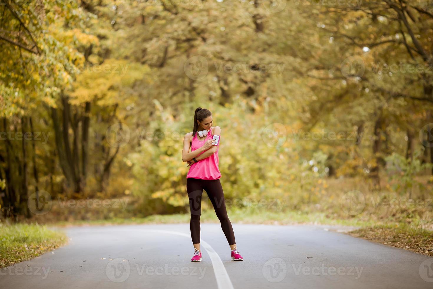 Mujer joven tiene un descanso durante el entrenamiento en el bosque de otoño foto