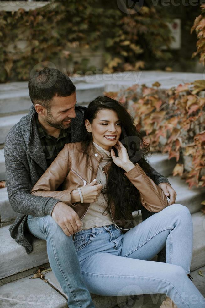 Young couple sitting on outdoor stairs on a autumn day photo