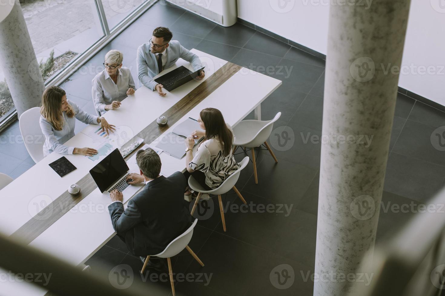 Vista aérea en un grupo de gente de negocios trabajando juntos y preparando un nuevo proyecto en una reunión en la oficina. foto