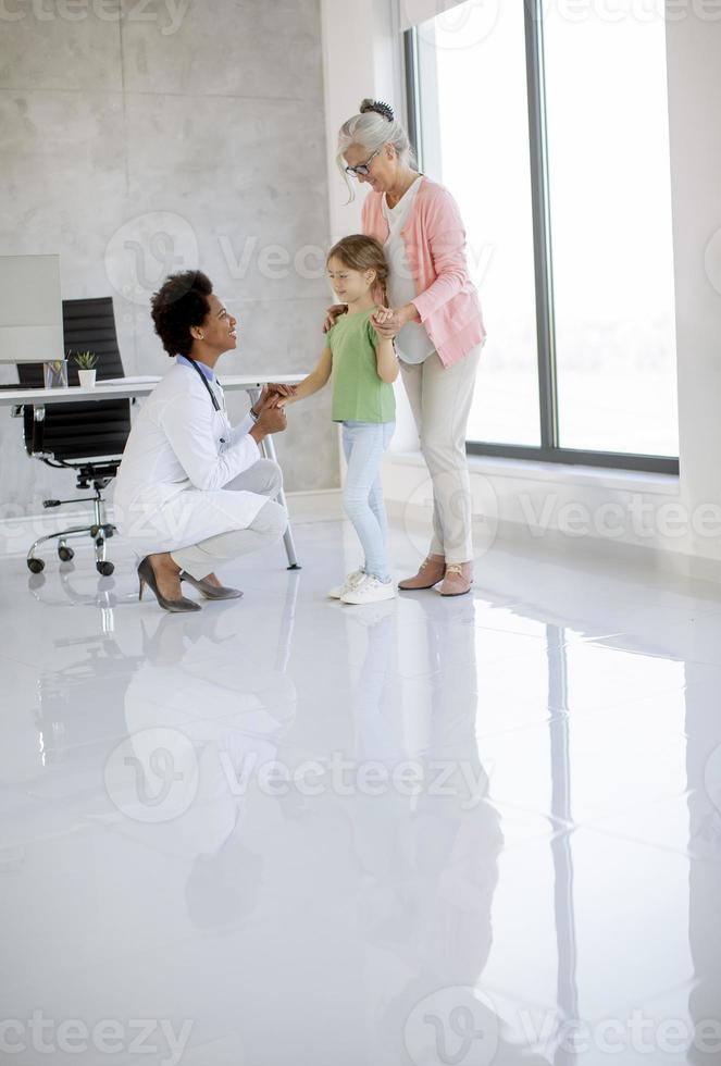 linda niña con su abuela en el examen del pediatra foto