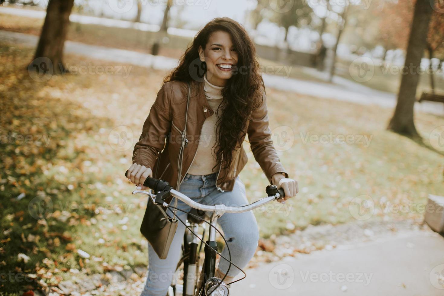 Young woman riding bicycle on autumn day photo