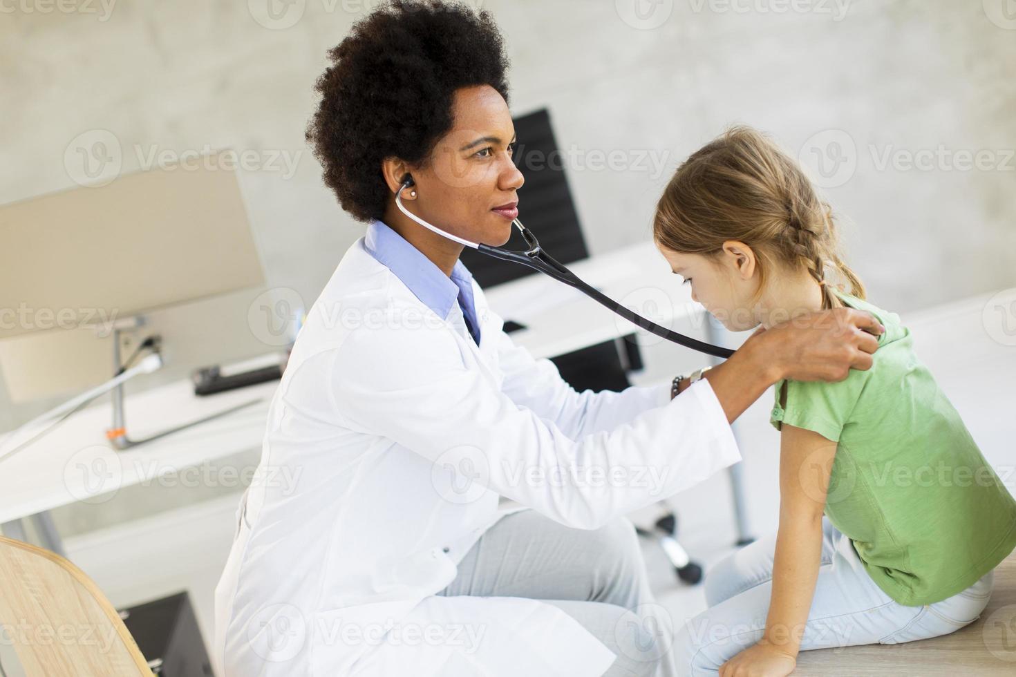 Cute little girl at the pediatrician examination photo