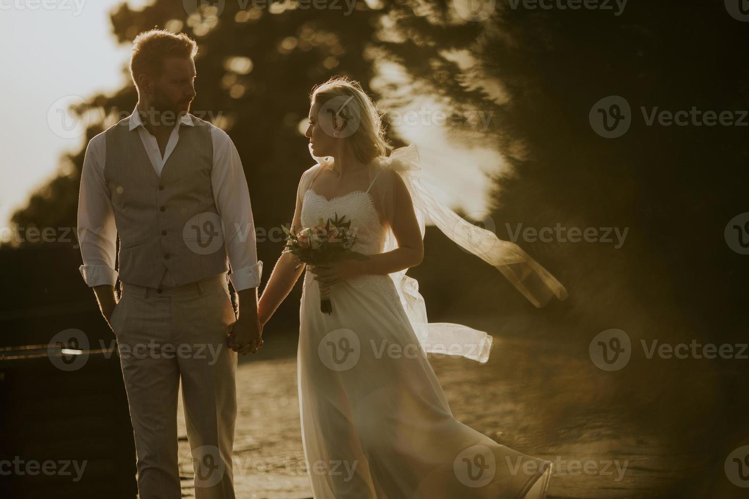 Young newlywed couple walking in the park photo