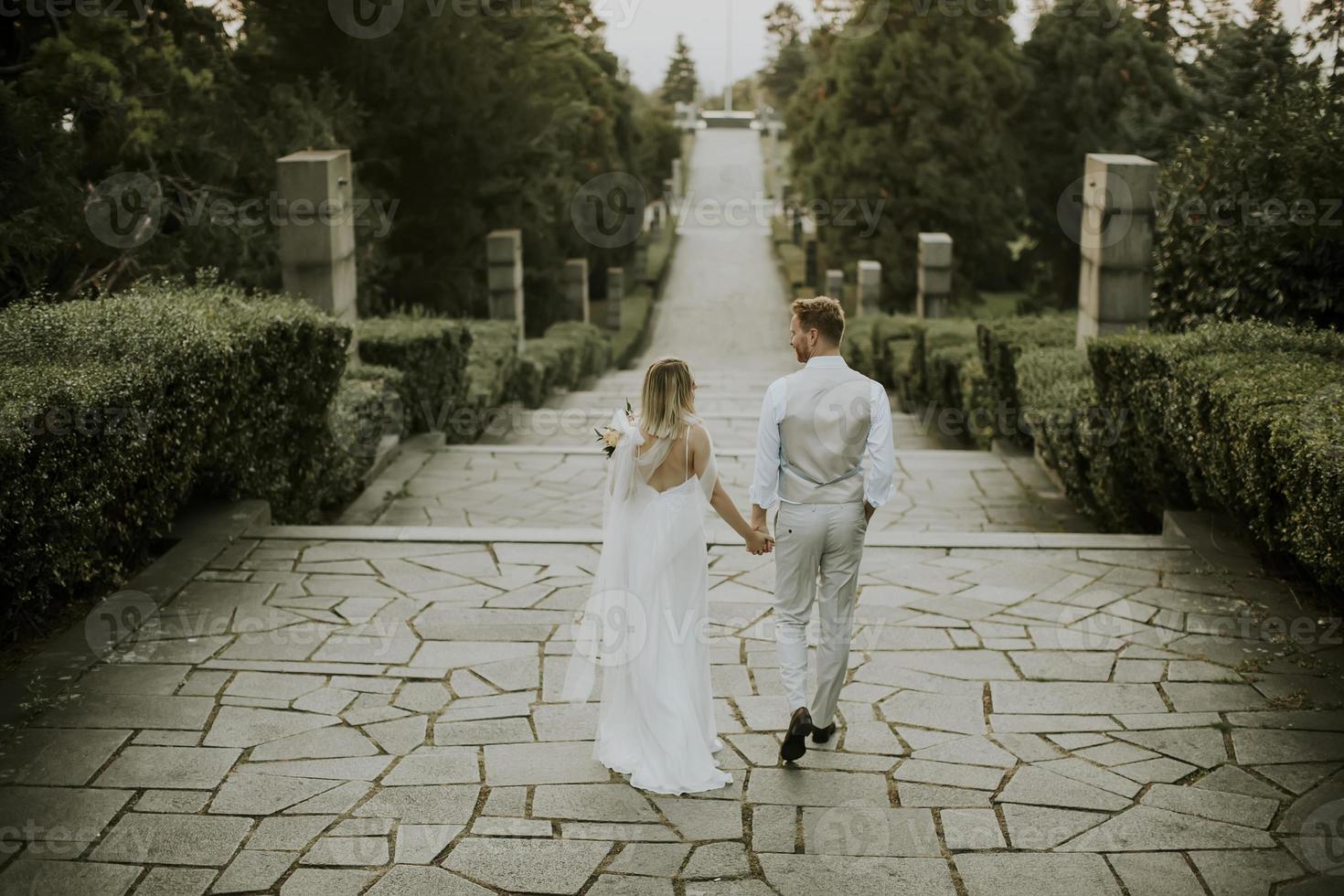 Young newlywed couple walking in the park photo