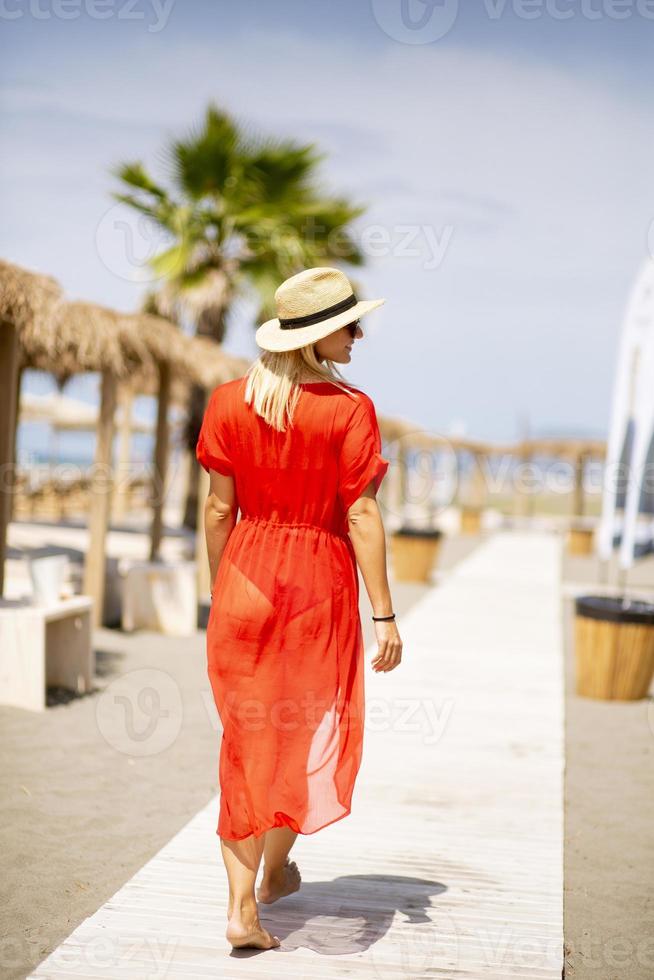 mujer joven, en, rojo, ambulante, en, playa, en, verano 5044356 de stock en