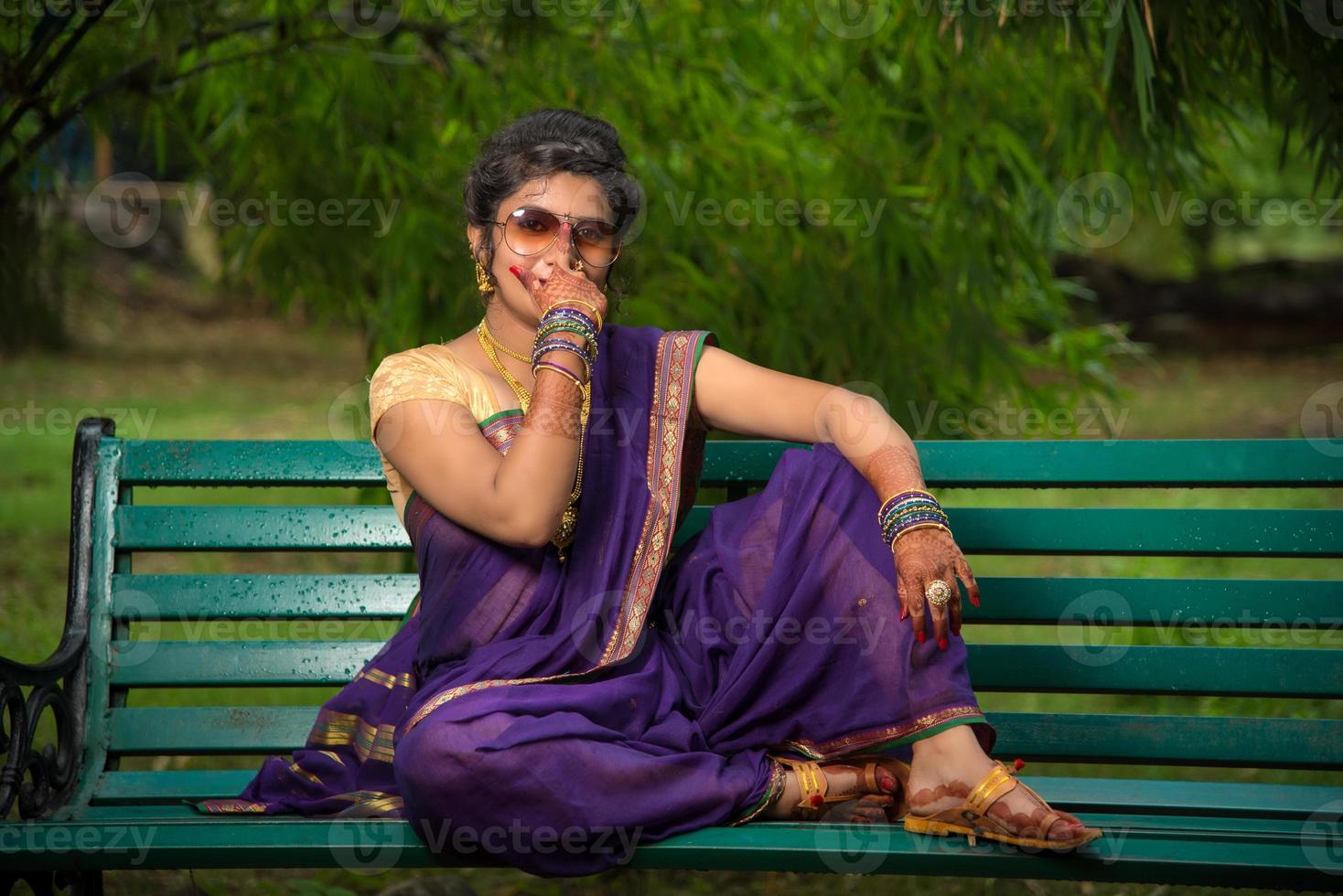 Hermosa joven india en sari tradicional posando al aire libre foto