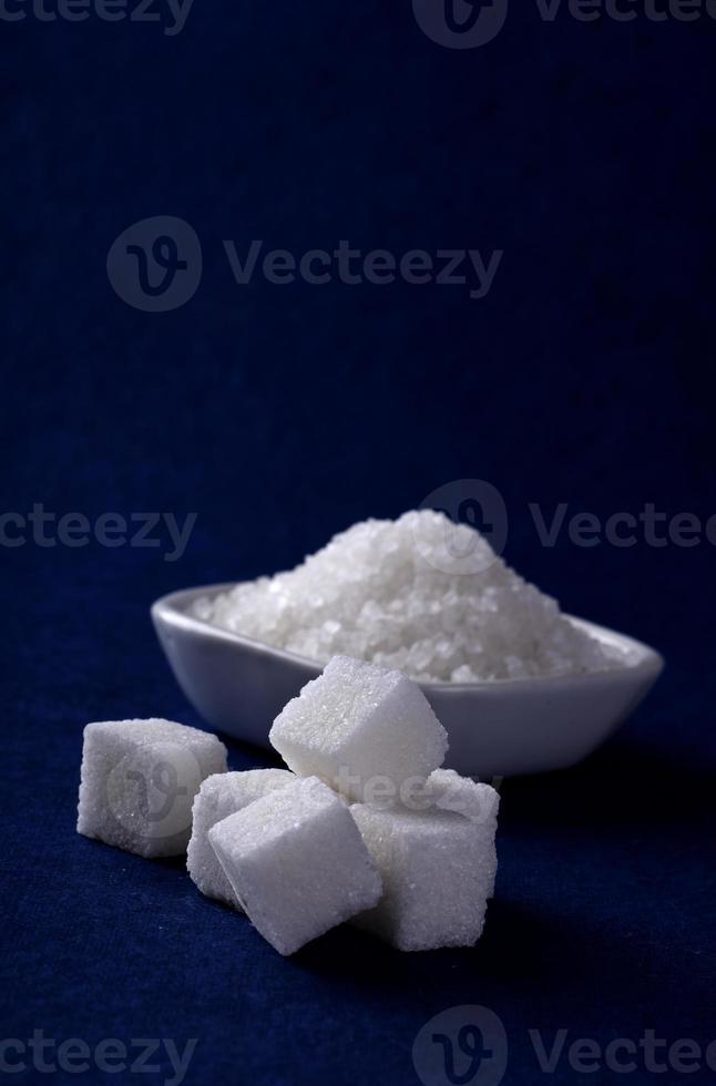 Sugar Cubes with Sugar in white plate on blue background photo