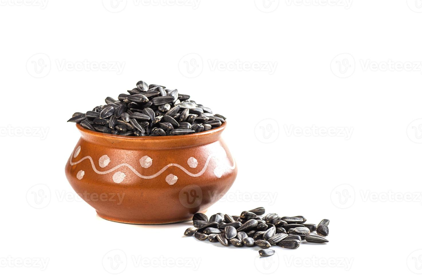 Sunflower Seeds in clay pot on white background. Helianthus annuus. photo