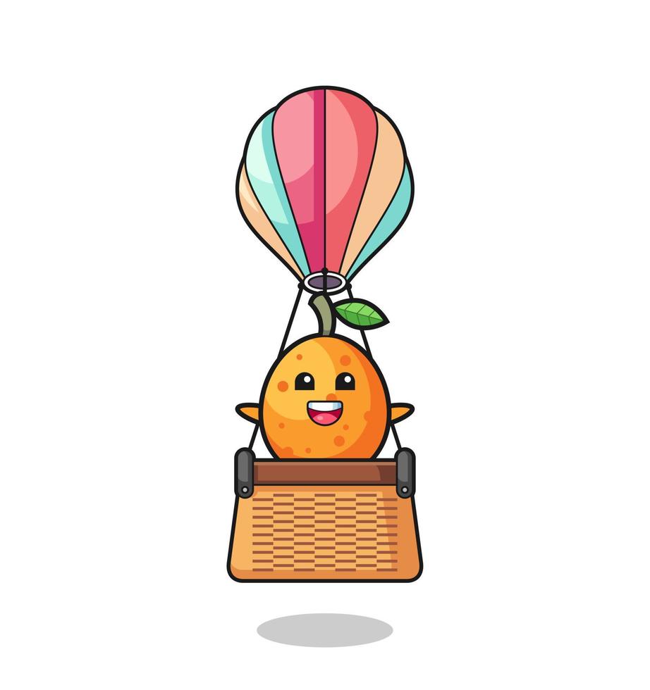mascota kumquat montando un globo aerostático vector