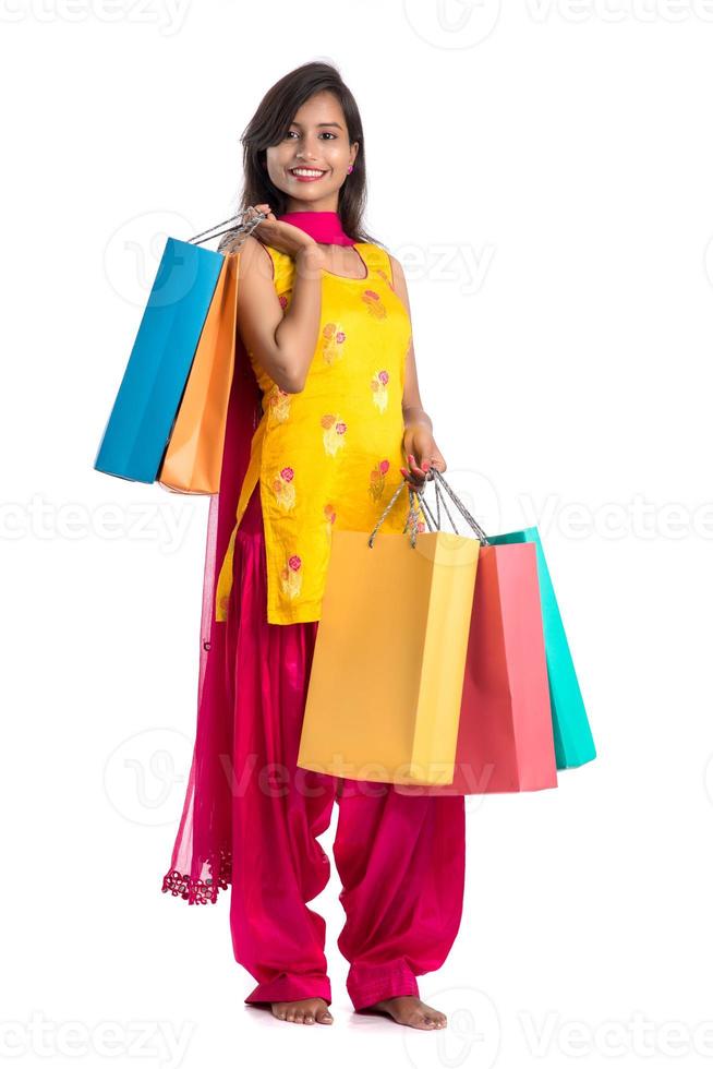 Beautiful Indian young girl holding and posing with shopping bags on a white background photo