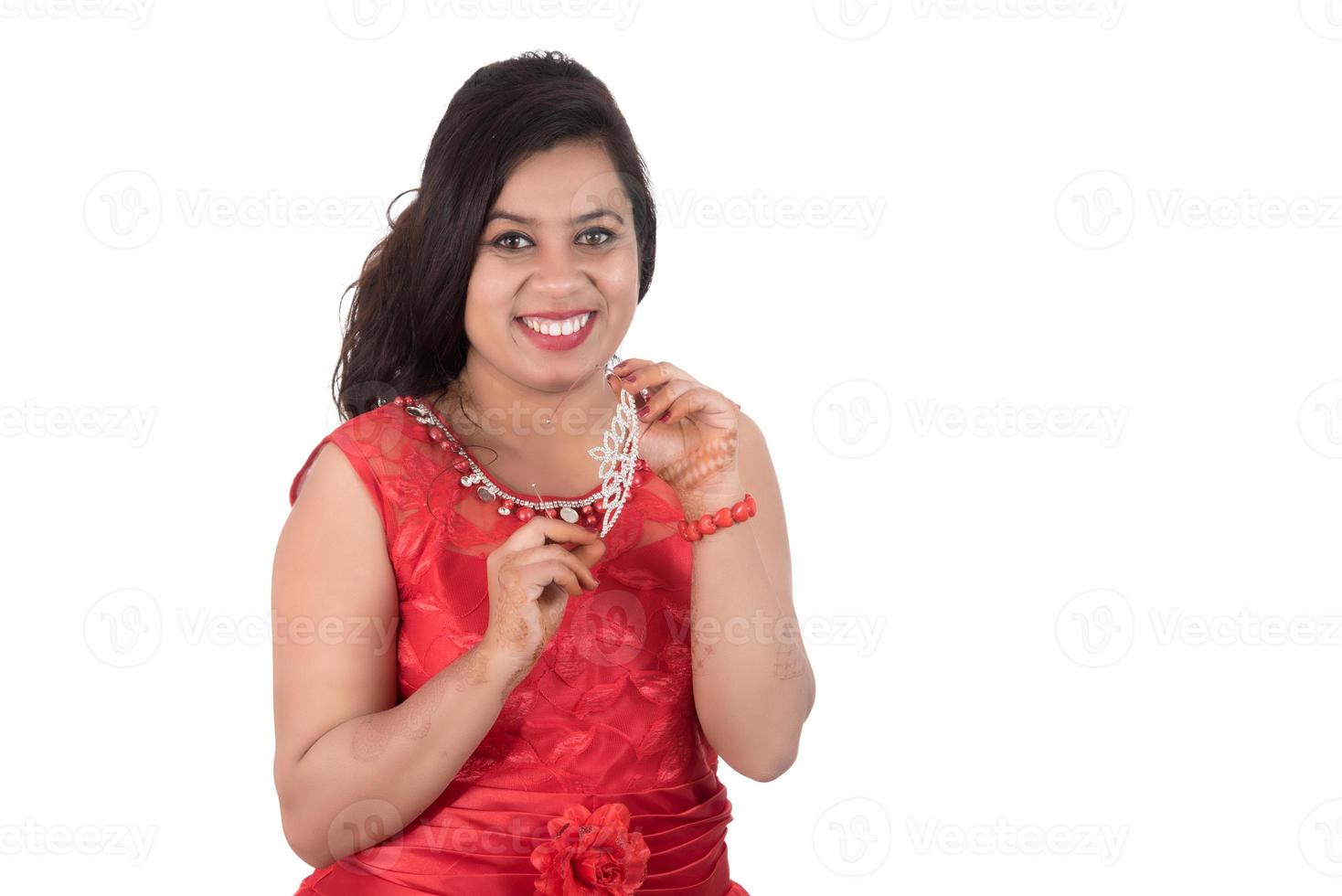 Young girl in red dress posing on white background photo