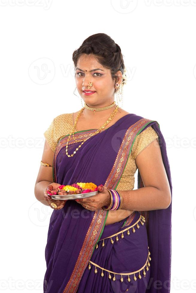 Portrait of a Indian Traditional Girl holding pooja thali with diya, Diwali or deepavali photo with female hands holding oil lamp during festival of light on white background