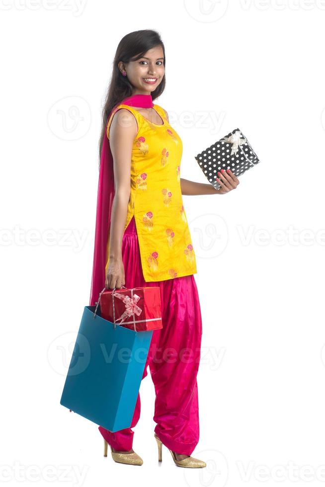 A beautiful woman posing with a shopping bag and gift Boxes on a white background. photo