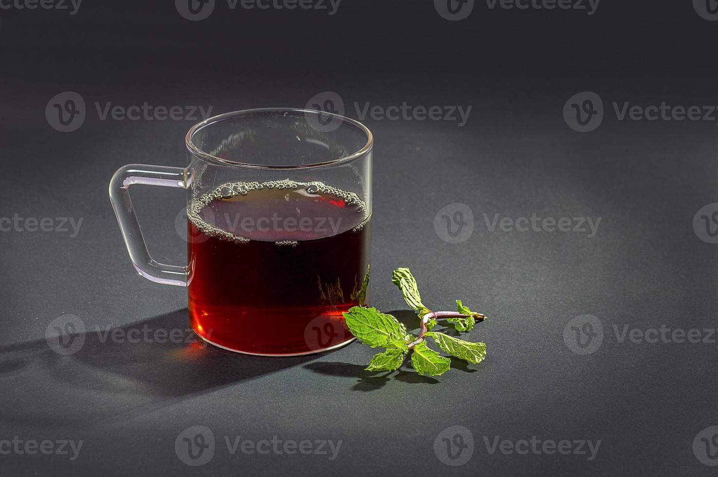 Cup of tea, mint and lemon on dark background photo