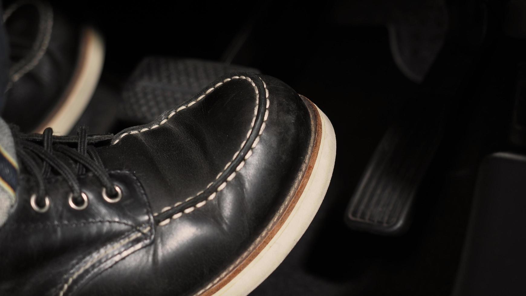 Close up the foot pressing foot pedal of a car to drive ahead. photo