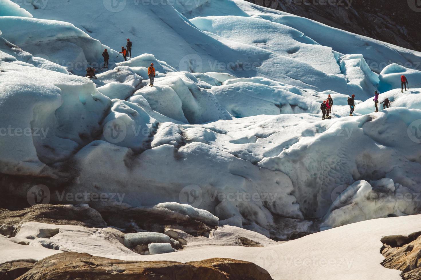 Private group of hiker walking on glacier. Glacier group of people hiking mountains photo