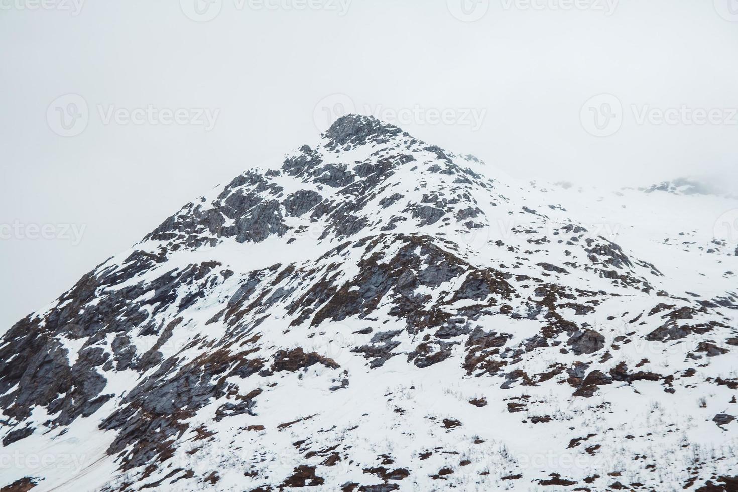 Mountain with snow cap. Mountain top in the snow on the background of the sky photo